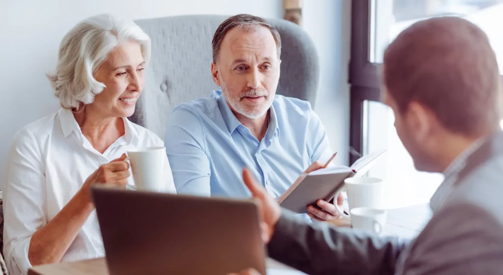 Un couple de seniors en entretien avec un conseiller pour un contrat d'obsèques.